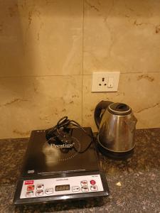 a tea kettle sitting on top of a stove at Taj Serenity Divine Luxe Retreat in Chhatikara