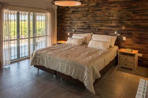 une chambre avec un lit et un mur en bois dans l'établissement Casa entre viñedo con vista a la Cordillera, à Las Compuertas