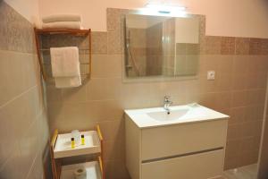 ein Badezimmer mit Waschbecken und Spiegel in der Unterkunft Appartement Lido de la Marana in Lucciana