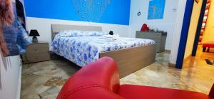 a bedroom with a bed and a red chair at Casa Giusi in Sferracavallo