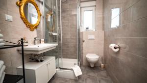 a bathroom with a sink and a toilet and a mirror at Trogir Padre Dante FREE PARKING and STARLINK High speed internet in Trogir +30 photos