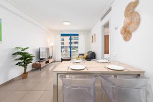 a living room with a large table with chairs at ApartUP Patacona Iconic I in Valencia