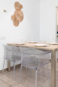 a dining room table with chairs and wine glasses at ApartUP Patacona Iconic I in Valencia
