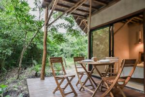 a wooden table and chairs on a wooden deck at Caravana junto al río en la huasteca potosina in Aquismón
