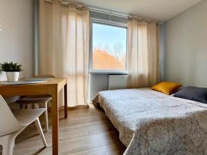 a bedroom with a bed and a desk and a window at K22 Park Mokotow Aparts in Warsaw