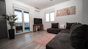 a living room with a couch and a tv at Trogir Padre Dante FREE PARKING and STARLINK High speed internet in Trogir