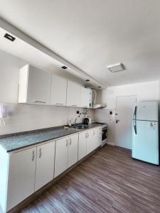 a kitchen with white cabinets and a refrigerator at Dpto Ituzaingo 1270 - 2 dormitorios in Cordoba