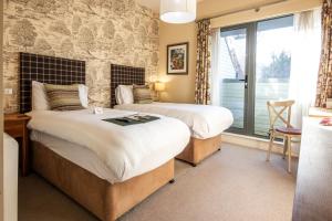 two beds in a room with a window at The White Hart, Wroughton in Swindon