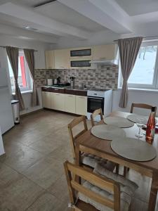 a kitchen and dining room with a table and chairs at Apartmány Hertvinka in Mladé Buky