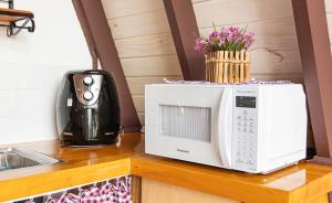 eine Mikrowelle auf einem Tresen mit Blumen in der Unterkunft Chalé Charlotte l Maravilhoso para Casal in Campos do Jordão + 13 Fotos