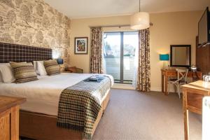 a hotel room with a bed and a window at The White Hart, Wroughton in Swindon