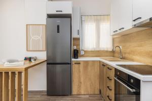 a kitchen with a stainless steel refrigerator and wooden cabinets at Tropical & Faces by Nest in Thessaloniki +24 photos