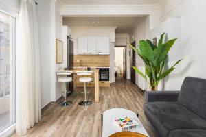 a living room with a couch and a kitchen at Tropical & Faces by Nest in Thessaloniki