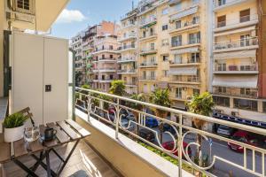 a balcony with a bench and some buildings at Tropical & Faces by Nest in Thessaloniki