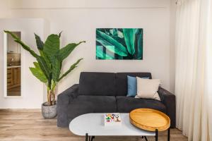 a living room with a couch and a table at Tropical & Faces by Nest in Thessaloniki