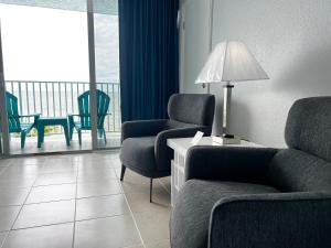 a living room with chairs and a table with a lamp at Lani Kai Island Resort in Fort Myers Beach +121 photos