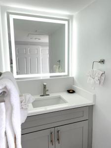a white bathroom with a sink and a mirror at Lani Kai Island Resort in Fort Myers Beach