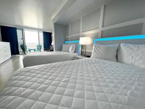 a large white bedroom with two beds and a balcony at Lani Kai Island Resort in Fort Myers Beach