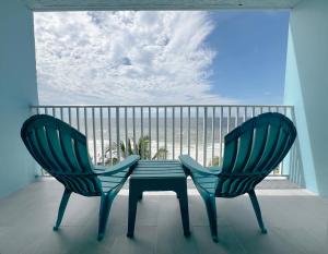 two chairs and a table on a balcony with the ocean at Lani Kai Island Resort in Fort Myers Beach
