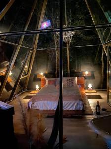 a bedroom with a bed in a glass house at Loft Vidro Pirâmide Rota do Vinho São Roque in São Roque