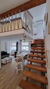 a room with a staircase and a living room with a table at Apartman Manuela in Pag