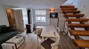 a living room with a couch and a table and stairs at Apartman Manuela in Pag