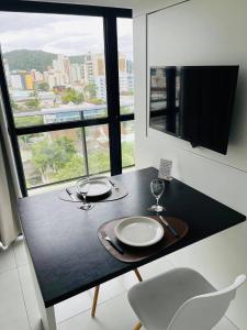 stół z dwoma talerzami i kieliszkami do wina w obiekcie MaxLoft V- Apto residencial completo w mieście Joinville +10 zdjęć