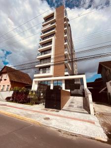 a tall building on the side of a street at MaxLoft V- Apto residencial completo in Joinville