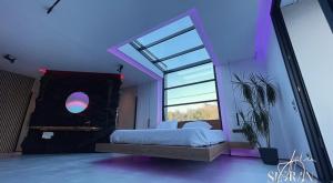a bedroom with a bed and a large window at Suite impériale LOVE ROOM in Sisteron