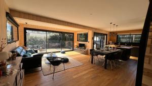Magnifique villa bois à Lacanau port في لاكانو: غرفة معيشة مع طاولة وغرفة طعام