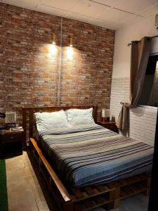 a bed in a room with a brick wall at L'orée du bois in Mbala +12 photos