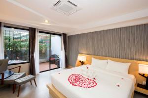 Un dormitorio con una cama con un corazón. en Apple A Day Resort Krabi, Ao Nang Beach - SHA Extra Plus, en Ao Nang Beach