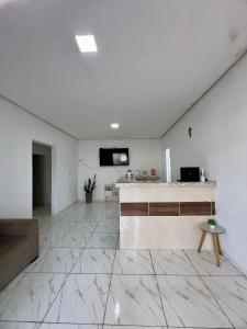 a white room with a counter and a tv on a wall at Pousada Velho Brito in Piranhas