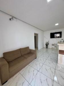 a living room with a couch and a tv on a wall at Pousada Velho Brito in Piranhas