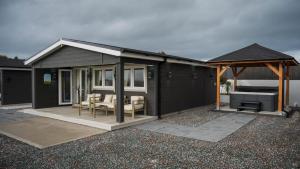 una casa nera con gazebo e grill di Danu Escape a Gneevgullia