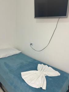 a bedroom with a bed with a towel on it at Pousada Velho Brito in Piranhas