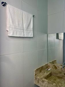 a bathroom with a tub and a towel on the wall at Pousada Velho Brito in Piranhas