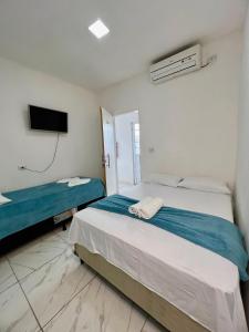 a bedroom with two beds and a flat screen tv at Pousada Velho Brito in Piranhas