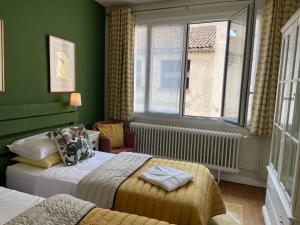 a hotel room with two beds and a window at Serendipity Eymet B&B in Eymet