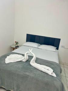 a pair of white towels laying on a bed at Pousada Velho Brito in Piranhas