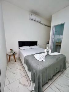a bedroom with a bed with a swan statue on it at Pousada Velho Brito in Piranhas