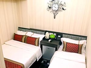 香港的住宿－季節酒店，酒店客房设有两张床和墙上的时钟。