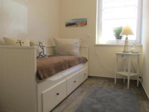 a small bedroom with a bed with a window at Ferienhaus mit Garten in Neßmersiel