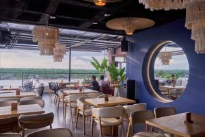 a restaurant with blue walls and tables and a mirror at Kamaleb Farallones Hotel in Quibdó