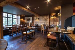 ein Restaurant mit Holzwänden und Tischen und Stühlen in der Unterkunft The White Hart, Wroughton in Swindon