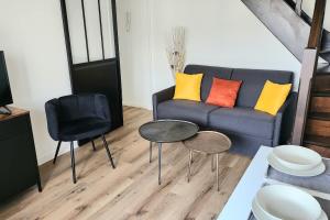 a living room with a couch and a table and chairs at Beautiful apartment with 3 balconies in Blonville-sur-Mer