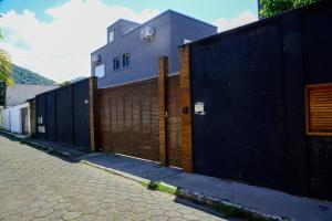 a building with a wooden gate and a fence at Casa a 150m da Praia de Boicucanga com piscina in São Sebastião