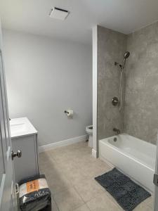 a bathroom with a bath tub and a toilet at Nottingham House near Southeastern University in Lakeland