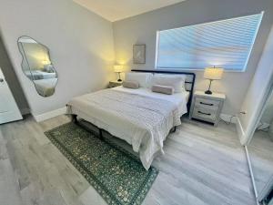 a bedroom with a bed with two pillows and a mirror at Nottingham House near Southeastern University in Lakeland