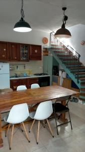 a kitchen with a wooden table and white chairs at La casa di Lilith in Sennori